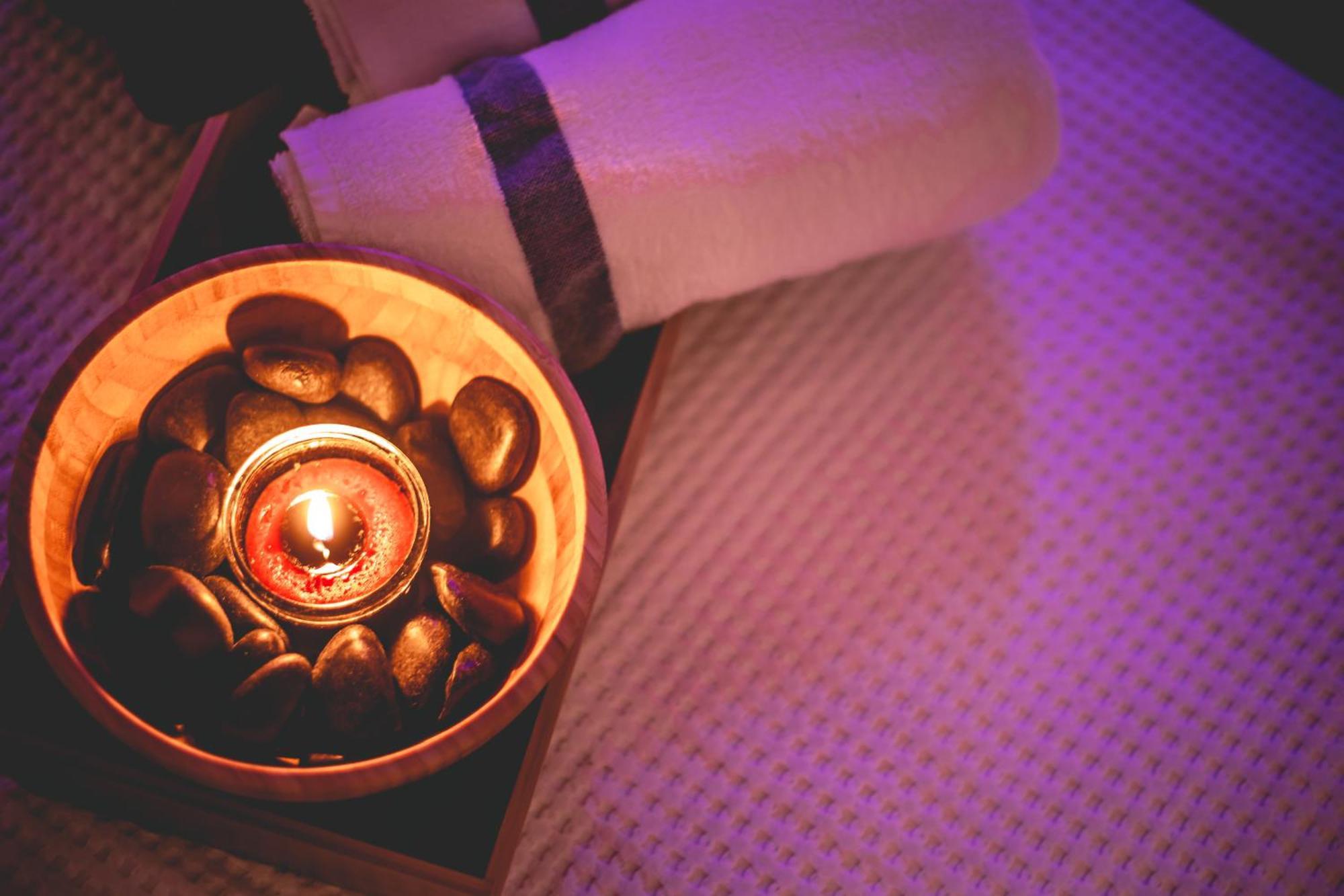 Daniel Herzliya Hotel Eksteriør billede A candle and stones on a massage table